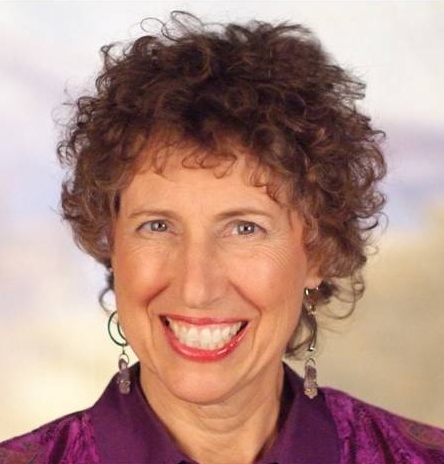 Smiling woman with curly hair and earrings