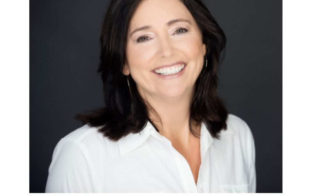Smiling woman in white blouse, gray background